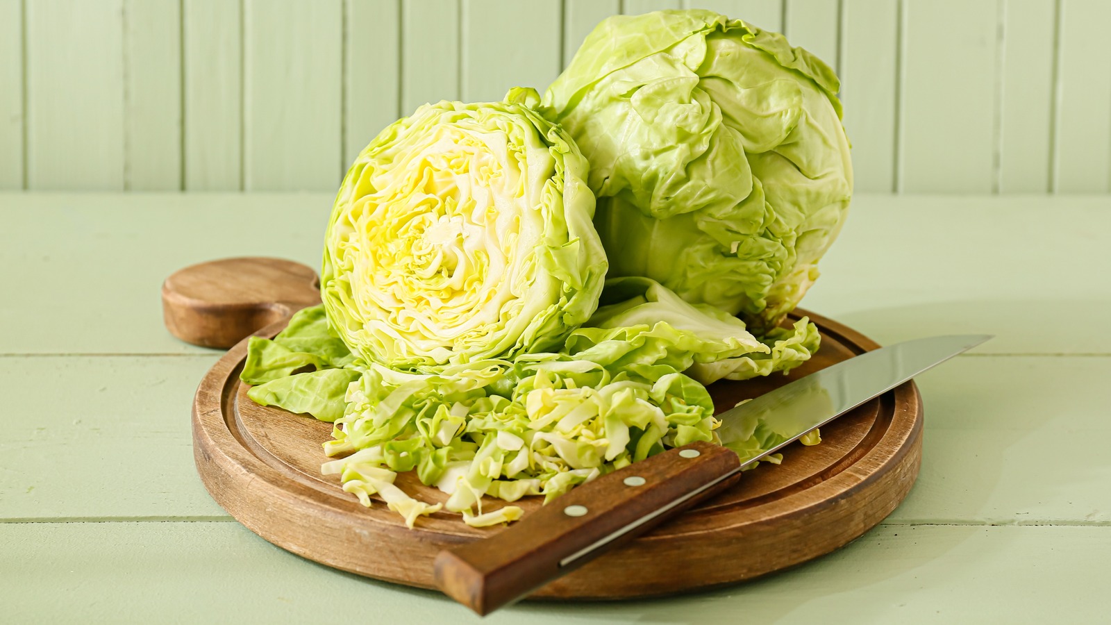 fresh cabbage cut in half on a chopping board
