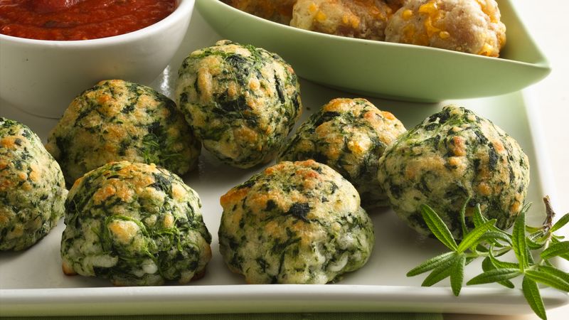 spinach balls with cheese on a plate with dips