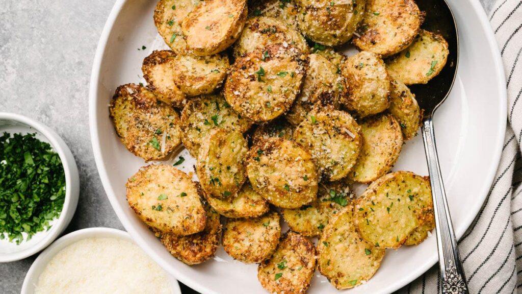 Delicious crispy parmesan potatoes with parsley and a creamy garlic dip